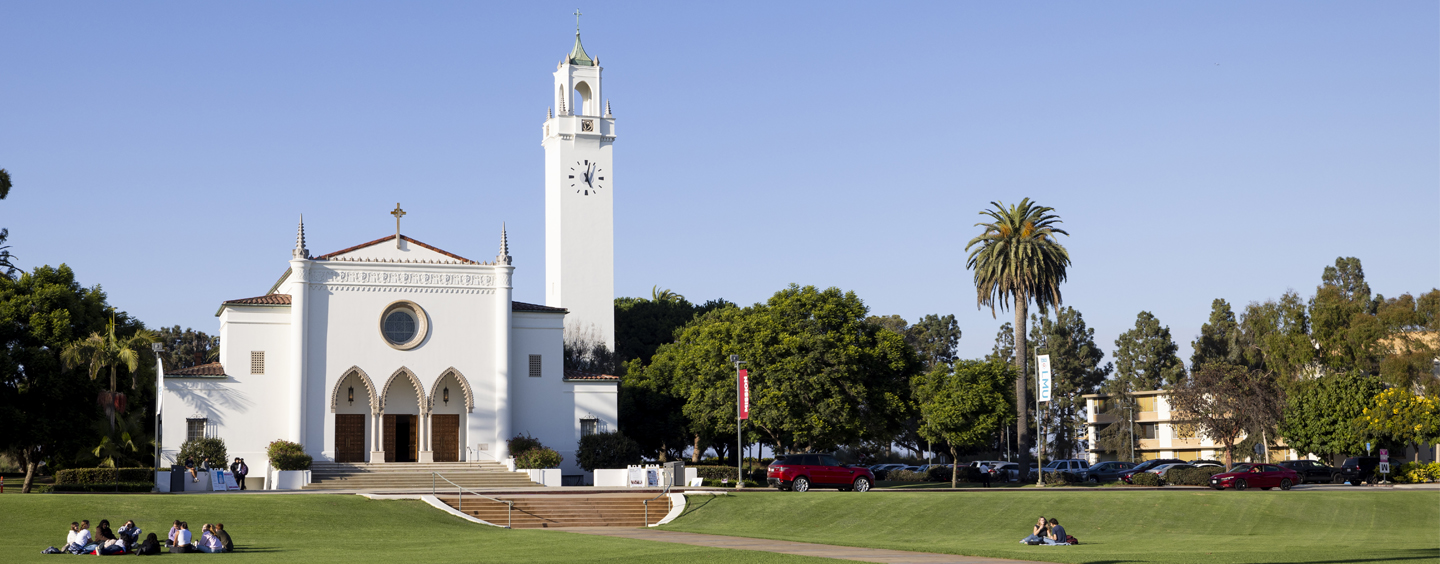 Sacred Heart Chapel with the Sunken Garden in the foreground and a blue sky in the background.